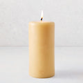 3x8 inch amber unscented pillar candle with a lit cotton wick and gold embossed HG logo on a light background.