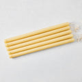 Set of five 15-inch amber hand-dipped taper candles with gold HG logo and cotton wicks.