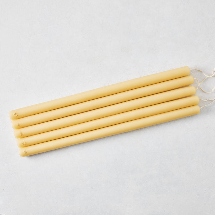 Set of five 17-inch amber hand-dipped taper candles with gold HG logo detail on a light background.