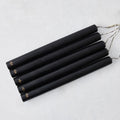 Set of five 10-inch black unscented taper candles with hand-embossed gold Hudson Grace logos on a white background.