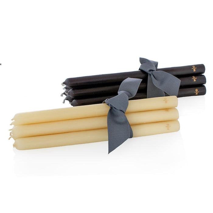 Two bundles of 12" unscented taper candles, one black and one cream, tied with gray ribbons.