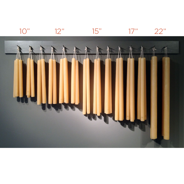 Five sets of unscented, hand-dipped amber taper candles in various lengths, from 10" to 22".