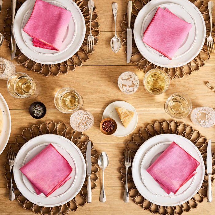 Bloom Woven Abaca Placemat, 15"Dia, natural brown, floral shape, under white plates with pink napkins.