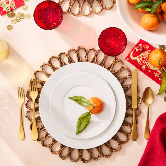 Bloom Woven Abaca Placemat, 15"Dia, natural brown, floral shape, under white plates with gold flatware.