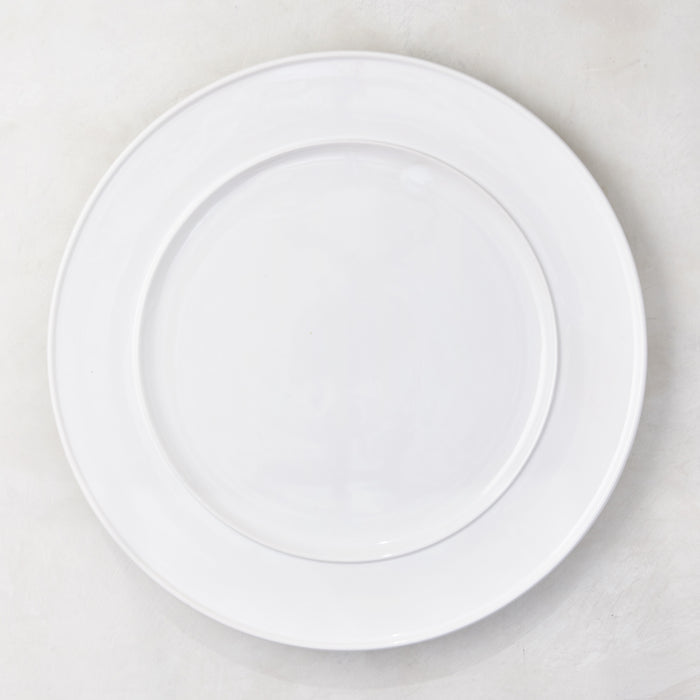 White round ceramic serving platter with a raised trimmed edge.