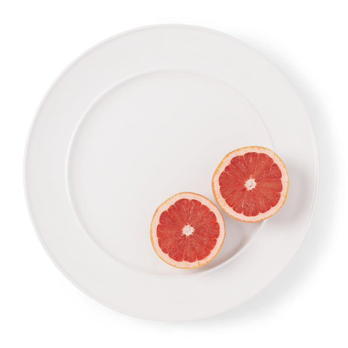 Bolinas Round Trimmed Ceramic Serving Platter in white with two grapefruit halves.