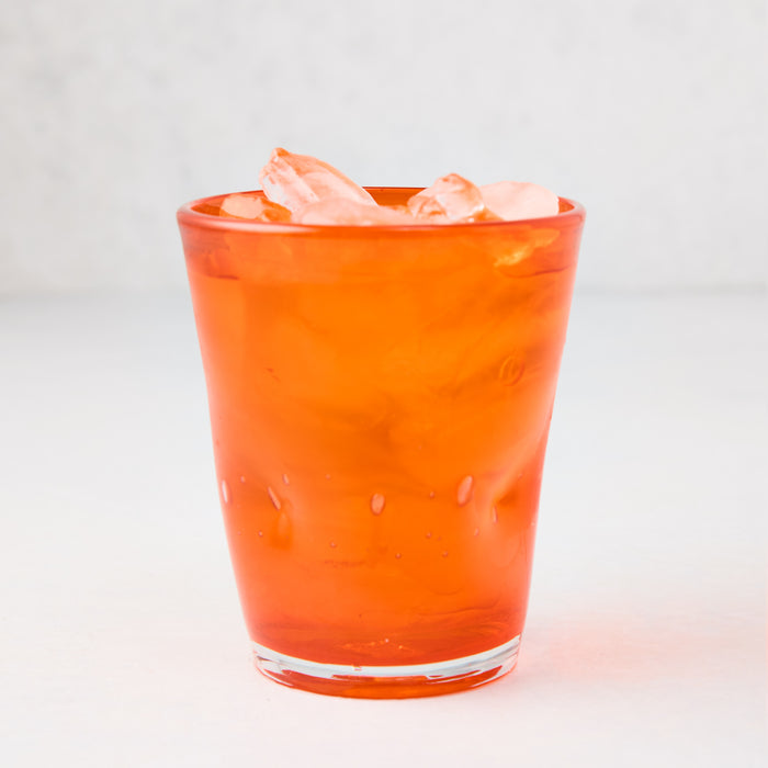 Dark orange Henri mouth-blown glass, 8 oz, filled with ice.
