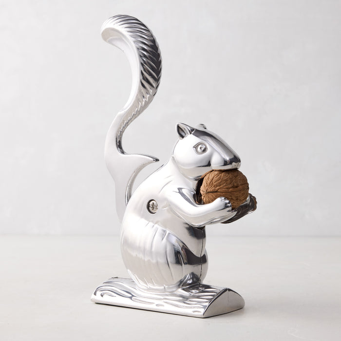 Silver metal squirrel nutcracker, "Davy Crackit," holding a walnut, on a light background.