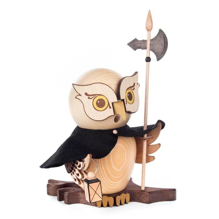 Side of Dregeno Owl Night Watchman crafted from natural wood and hand-carved in Germany. It features a traditional cloak and holds a lantern and halberd with each wing while standing on a wooden base.
