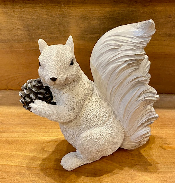 A white squirrel resin figurine hand-painted, holding a pine cone. This image is showing the left side.