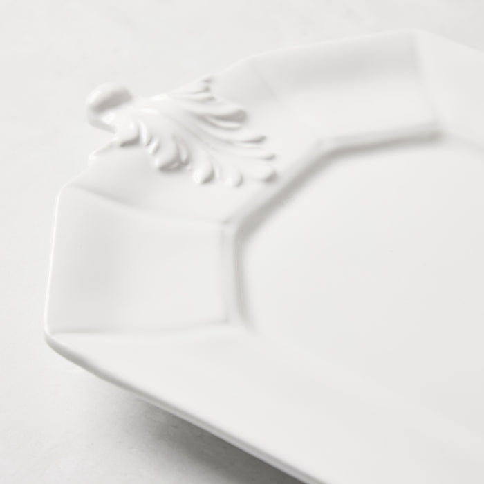 White octagon ceramic serving platter with raised Fleur de Lys detail.