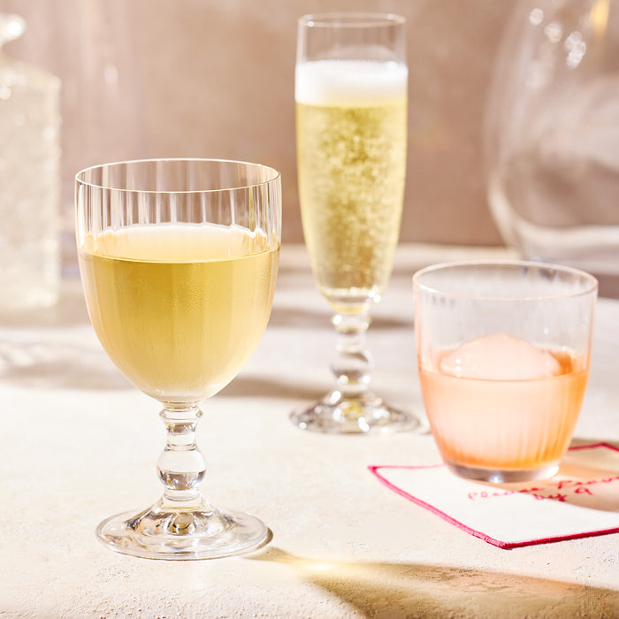 Georgia Eco-Crystal Champagne Glass, 8oz, with ribbed clear glass, filled with white wine.