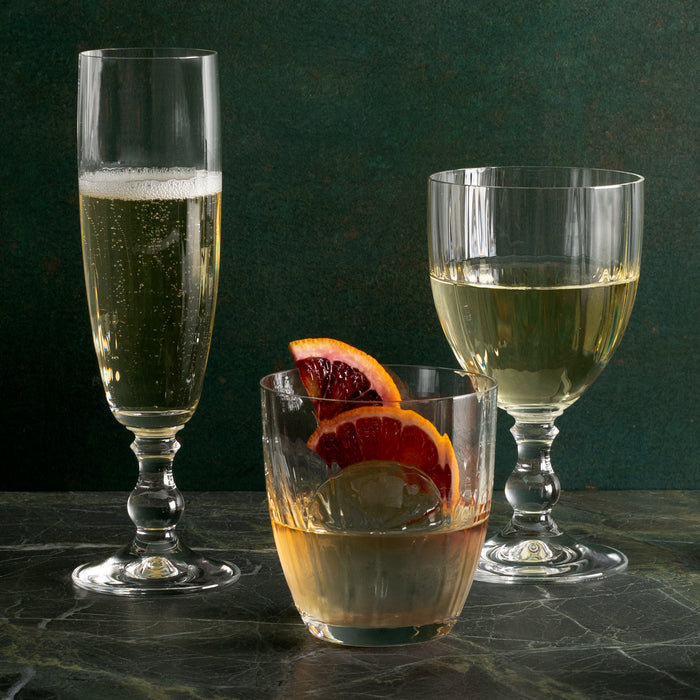 Georgia Eco-Crystal Champagne Glass, 8oz, with ribbed design, next to other glassware.