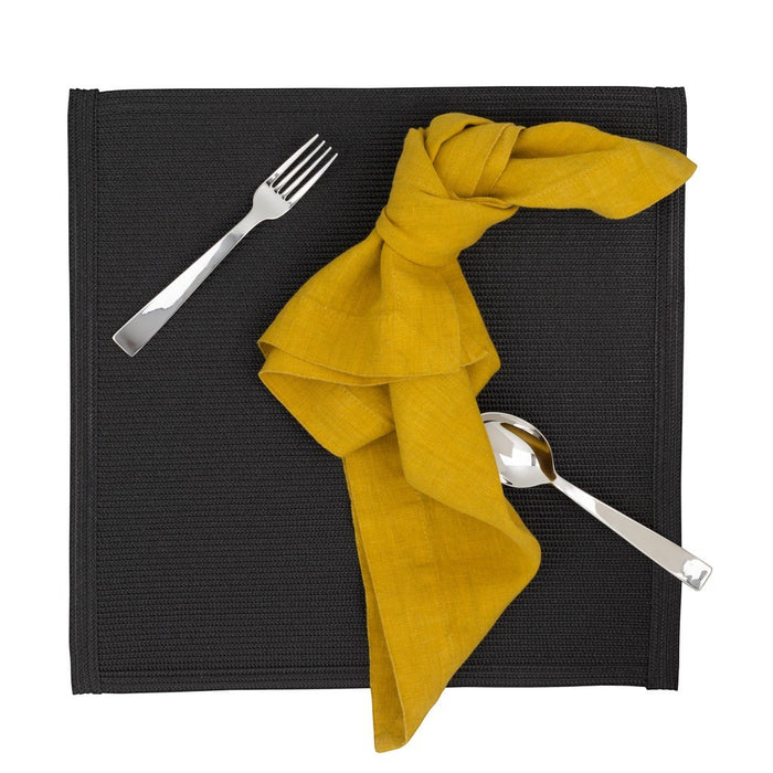 Gio Ponti Stainless Steel flatware: fork, knife, spoon, on a black placemat with a yellow napkin.