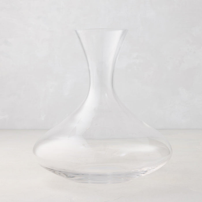Clear mouth-blown glass wine carafe, 50 oz, with a broad base and curved neck.