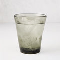 Grey Henri mouth-blown glass, 8 oz, filled with ice and a bubbly drink.