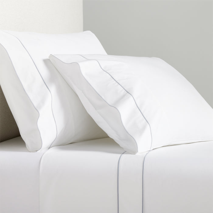 White percale sheet set with grey satin stitch border on pillows and flat sheet.