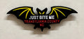 A metal black bat hat/lapel pin with the text 'JUST BITE ME, TRANSYLVANIA COUNTY, NC' on it.