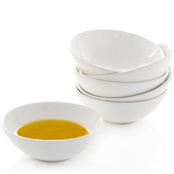Creamy white ceramic dipping bowls, one filled with olive oil, a stack of four behind it.