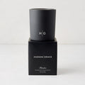Hudson Grace Bleecker Scented Candle, black matte glass vessel with HG logo, on its black box.
