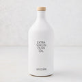 Hudson Grace Extra Virgin Olive Oil in a white ceramic bottle with a wood cork and black label.