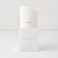 Hudson Grace Greenwich Scented Candle, white glass vessel with "HG" logo, on a white box.