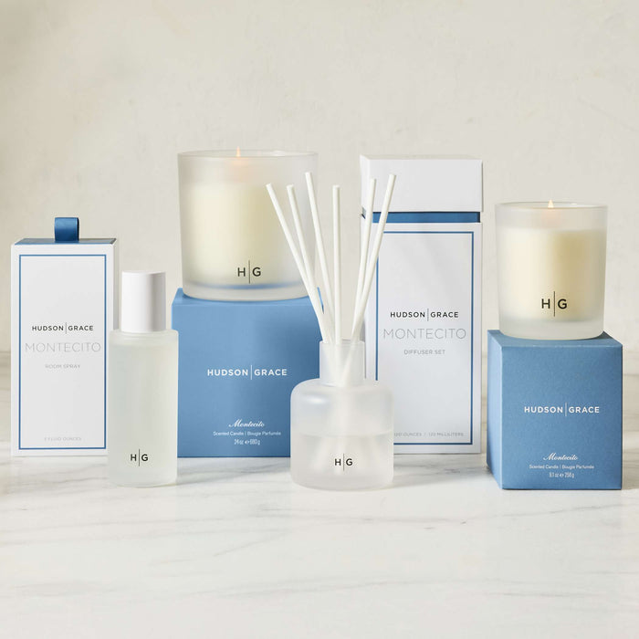 Hudson Grace Montecito scented candles, room spray, and diffuser set in white glass and blue packaging.