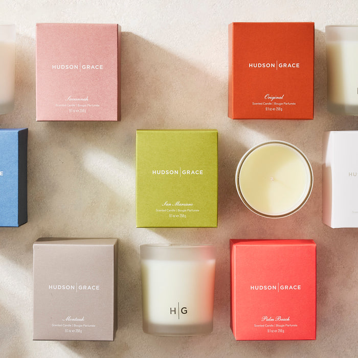 Hudson Grace San Marzano scented candle in a green box, surrounded by other colorful candle boxes and glass candles.