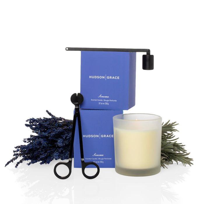 Hudson Grace Sonoma Scented Candle in a frosted glass vessel, with two blue boxes, lavender, and black wick tools.