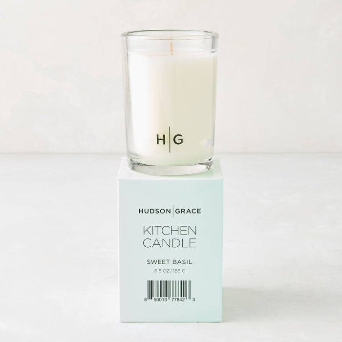 Hudson Grace Sweet Basil Kitchen Candle, white wax in clear glass, on a light teal box with black text.
