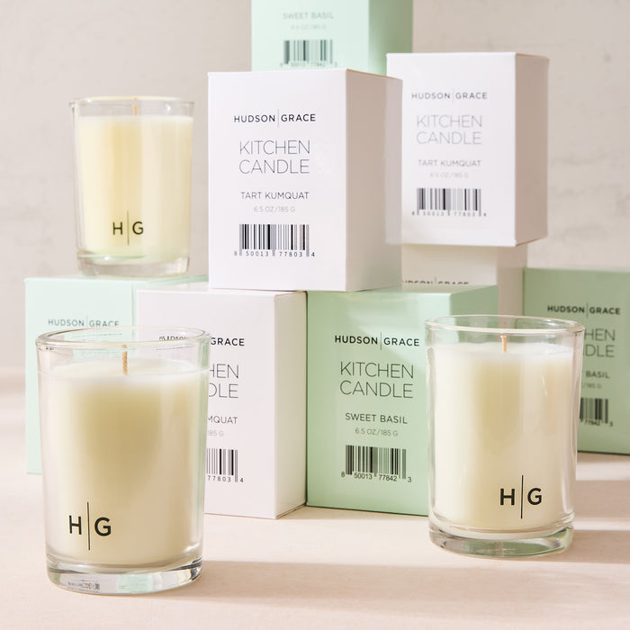 Hudson Grace Sweet Basil Kitchen Candle in a clear glass jar with white wax, alongside white and mint green boxes.