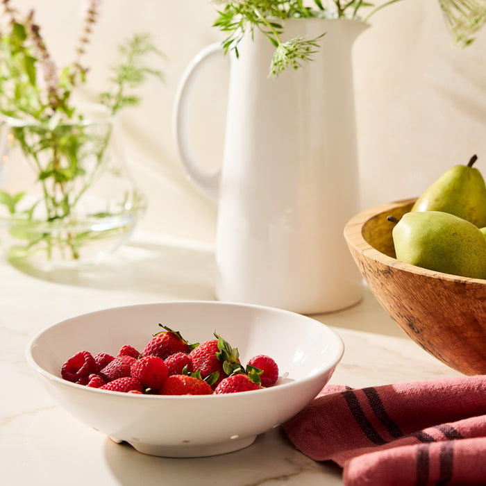 Hudson Grace white ceramic berry bowl with raspberries and strawberries on a marble counter.