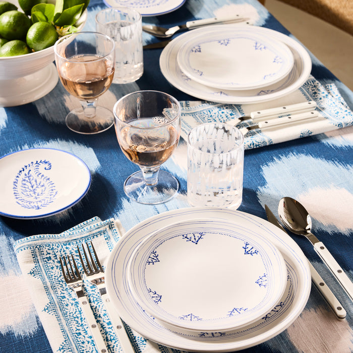 Hudson Water Goblet, clear chunky glass, on a blue and white patterned table setting.