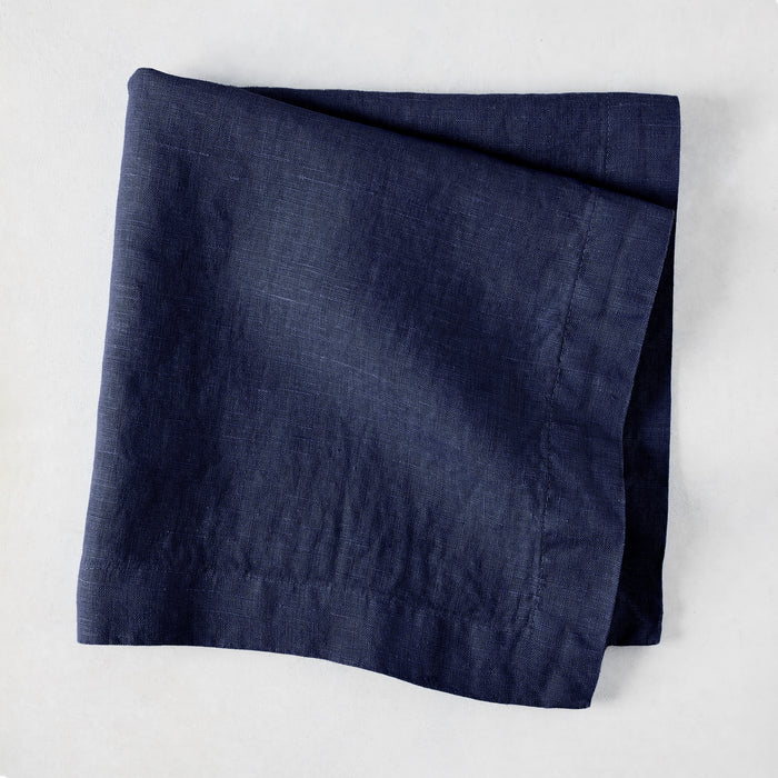 Folded Indigo HG Signature hand-dyed linen napkin, 22-inch square, with mitered corners.