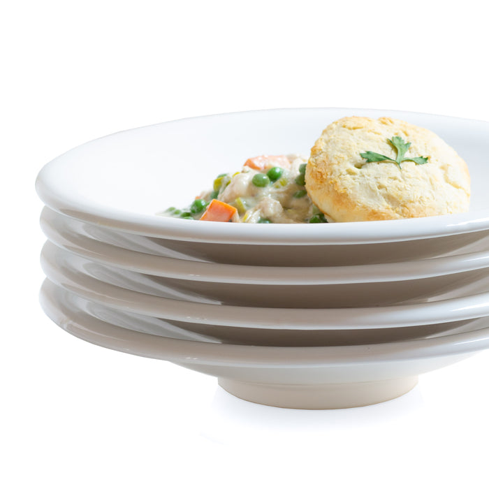 Stack of white ceramic pasta bowls with a single bowl holding chicken pot pie and a biscuit.
