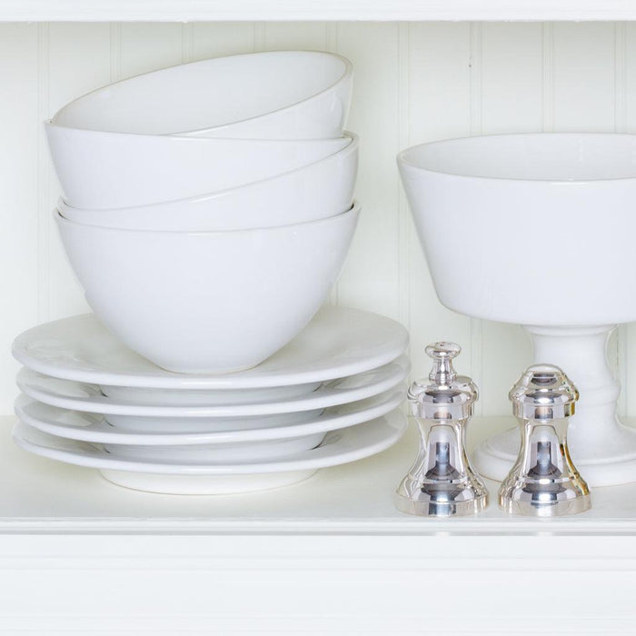 Creamy white Italian ceramic compote, footed bowl, and stacked plates with two silver shakers.