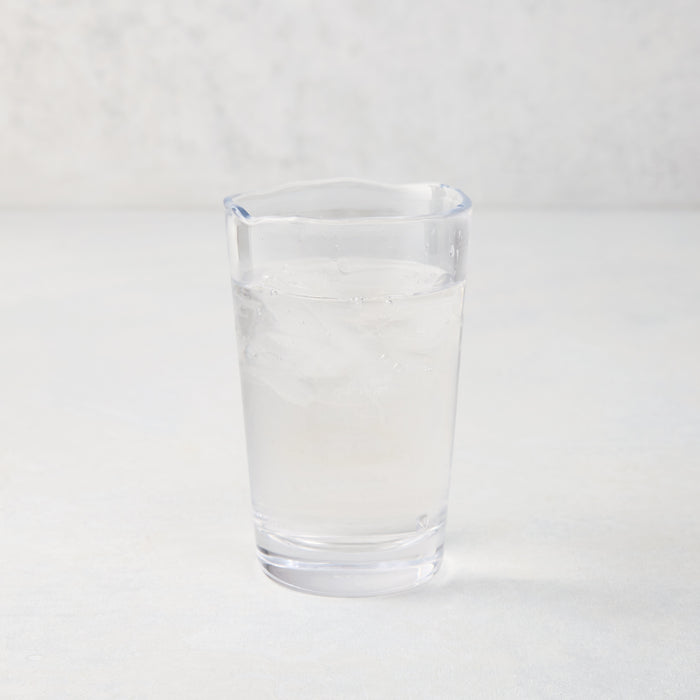 Jacob Scissor-Cut Glass Tumbler, 8 oz., clear, thick air-blown glass with rippled rim, filled with water and ice.