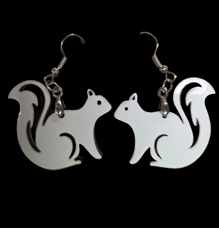 Squirrel-shaped earrings on a black background