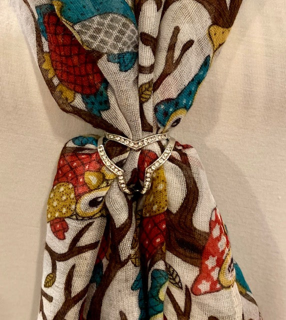 A scarf ring with crystal embellishments shown here with a multicolored scarf (sold separately).