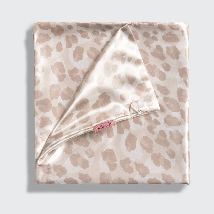Folded satin pillowcase with beige leopard print on a light gray background