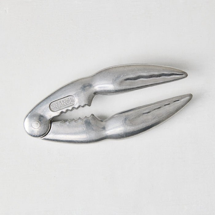 Laguiole Jean Dubost aluminum seafood crab cracker, claw-shaped, 5.5"L, with "FRANCE" embossed.