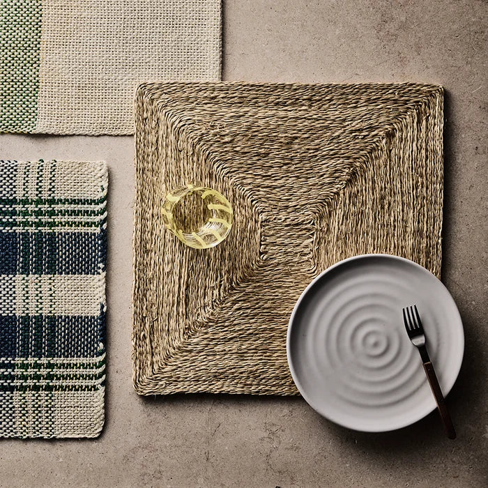 Natural abaca woven square placemat, 15" square, with plate, fork, and glass.