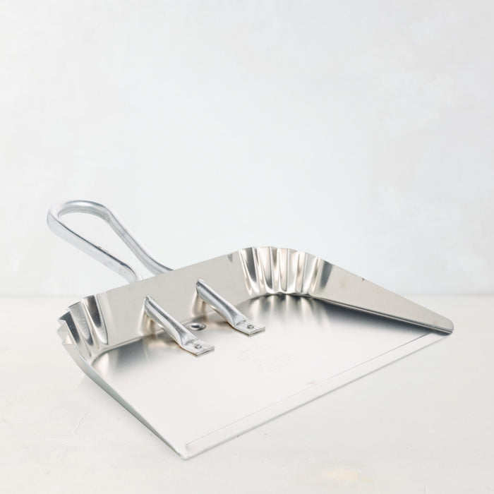 Large, flat-lying aluminum dust pan with a silver handle, designed for hands-free use.