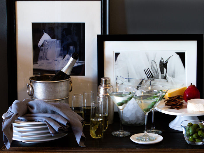Large handblown glass ice bucket with handles, holding a champagne bottle.