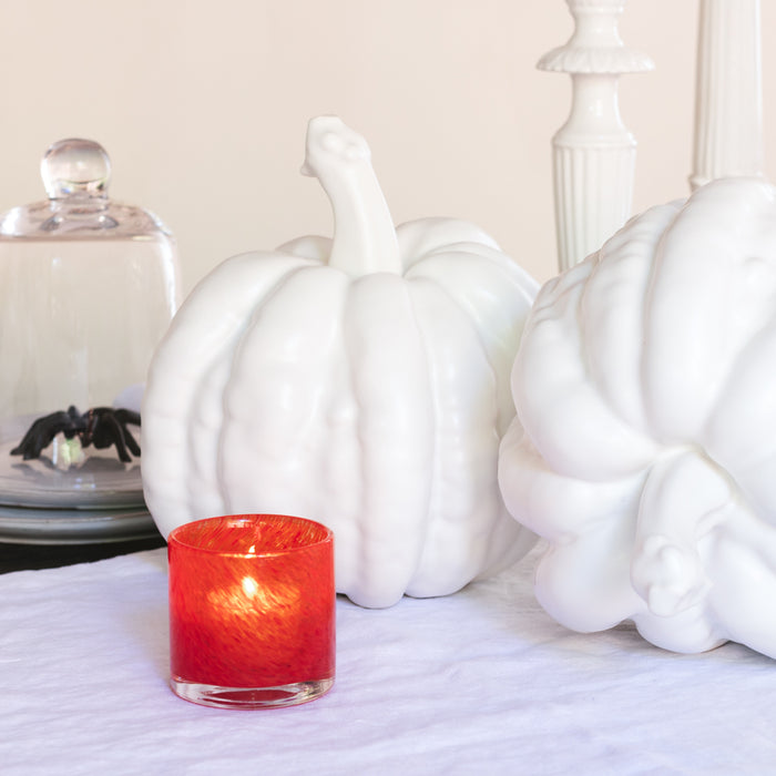 Large matte white ceramic pumpkin, 12"H x 10"Dia, with a red candle and spider decor.