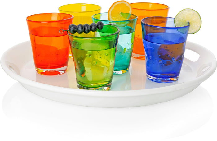 Mouth-blown Henri glasses in light orange, yellow, green, teal, and blue, filled with drinks on a white tray.