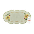 Sand color table runner with scalloped edges, with a border of sunflowers on either end of the runner.