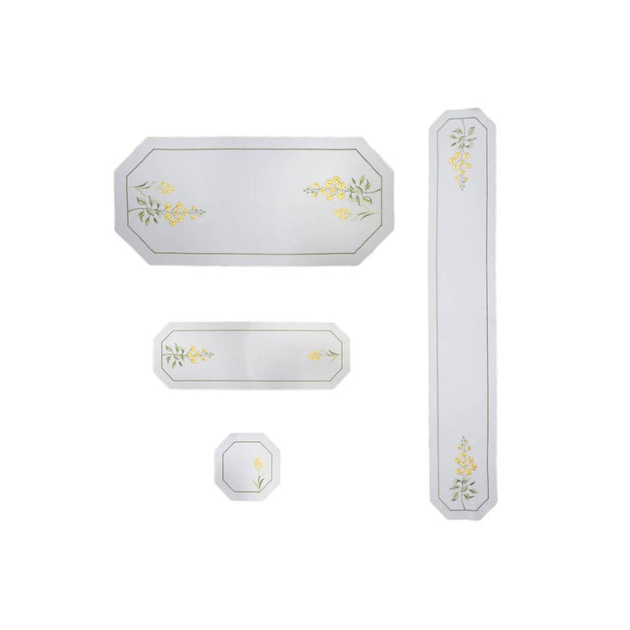 Summer Meadow Collection table linens, including linen table runners, square doily, and tablecloth, embroidered with yellow flowers, Swarovski crystals, and green stems. Displayed together in a bright, elegant setting. Made in Germany.