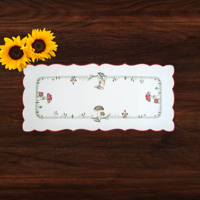 German embroidered table runner with mushroom and woodland design displayed on a dark wood table with sunflowers