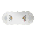 White linen table runner with embroidered candle and holly design and decorative sheer cutout details